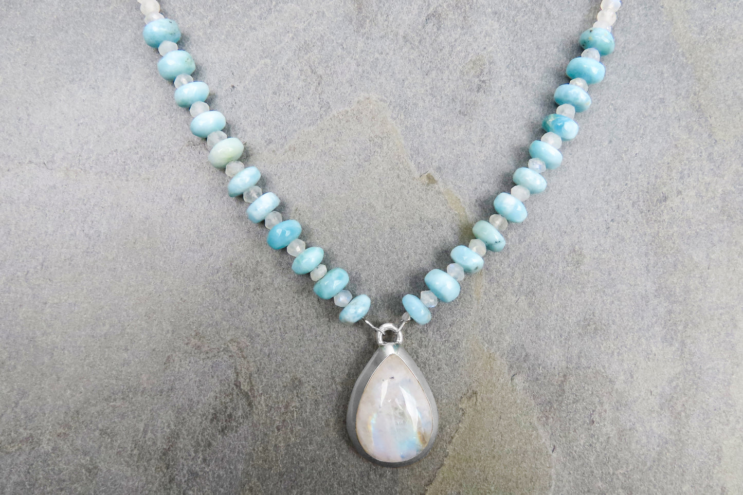 Long collier tendance pierre de lune arc-en-ciel Larimar avec style et élégance accrocheuse qui affine les tenues pour les occasions spéciales.